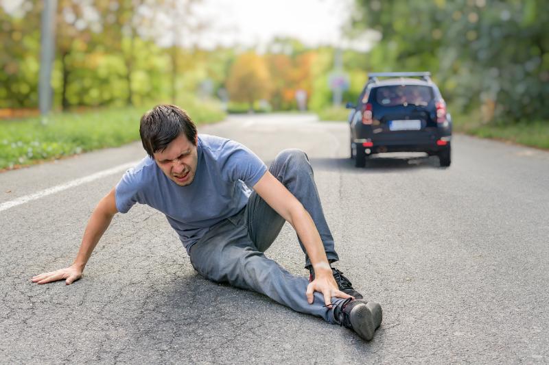 A man holding his leg after an on-road injury